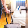 Persoon komt hotelkamer binnen met koffer 2