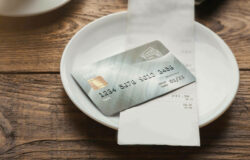 Credit card on small plate in restaurant with receipt 1500x1000